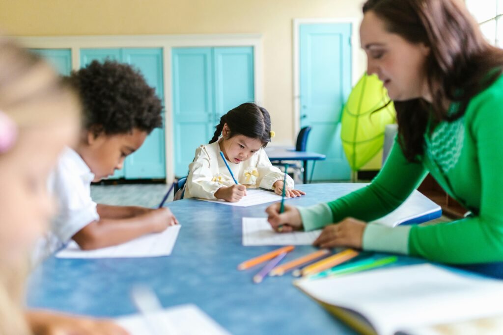 A child holds a colored pencil, her face pensive and focused on her online writing programs.